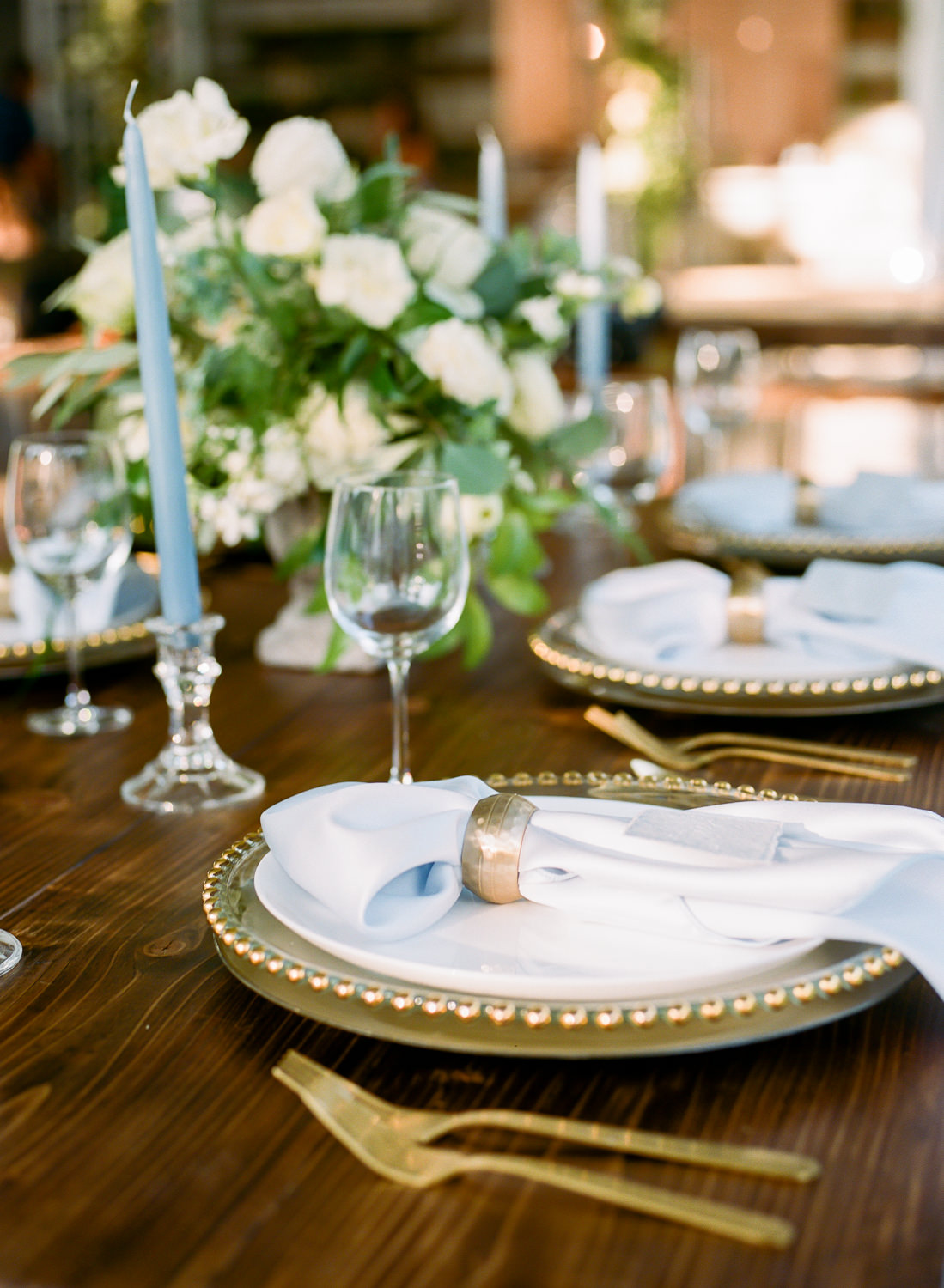 Wedding gold place settings, blue linens, Erica Robnett Photography