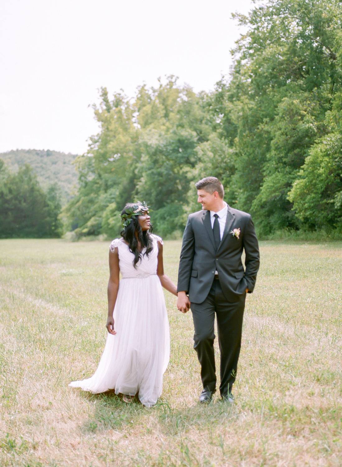 bride in grecian and leaf crown, groom in dark suit walking and holding hands, Erica Robnett Photography