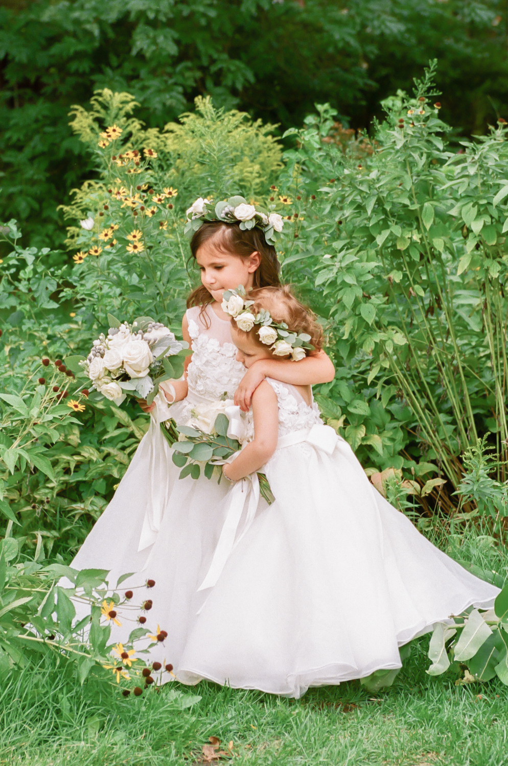 Flowers girls with flower crowns hugging each other, St. Louis fine art wedding photographer Erica Robnett Photography