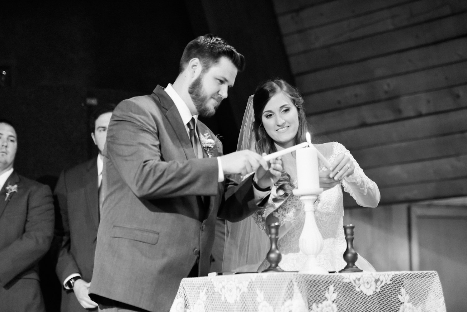 Bride and groom lighting unity candle; black and white