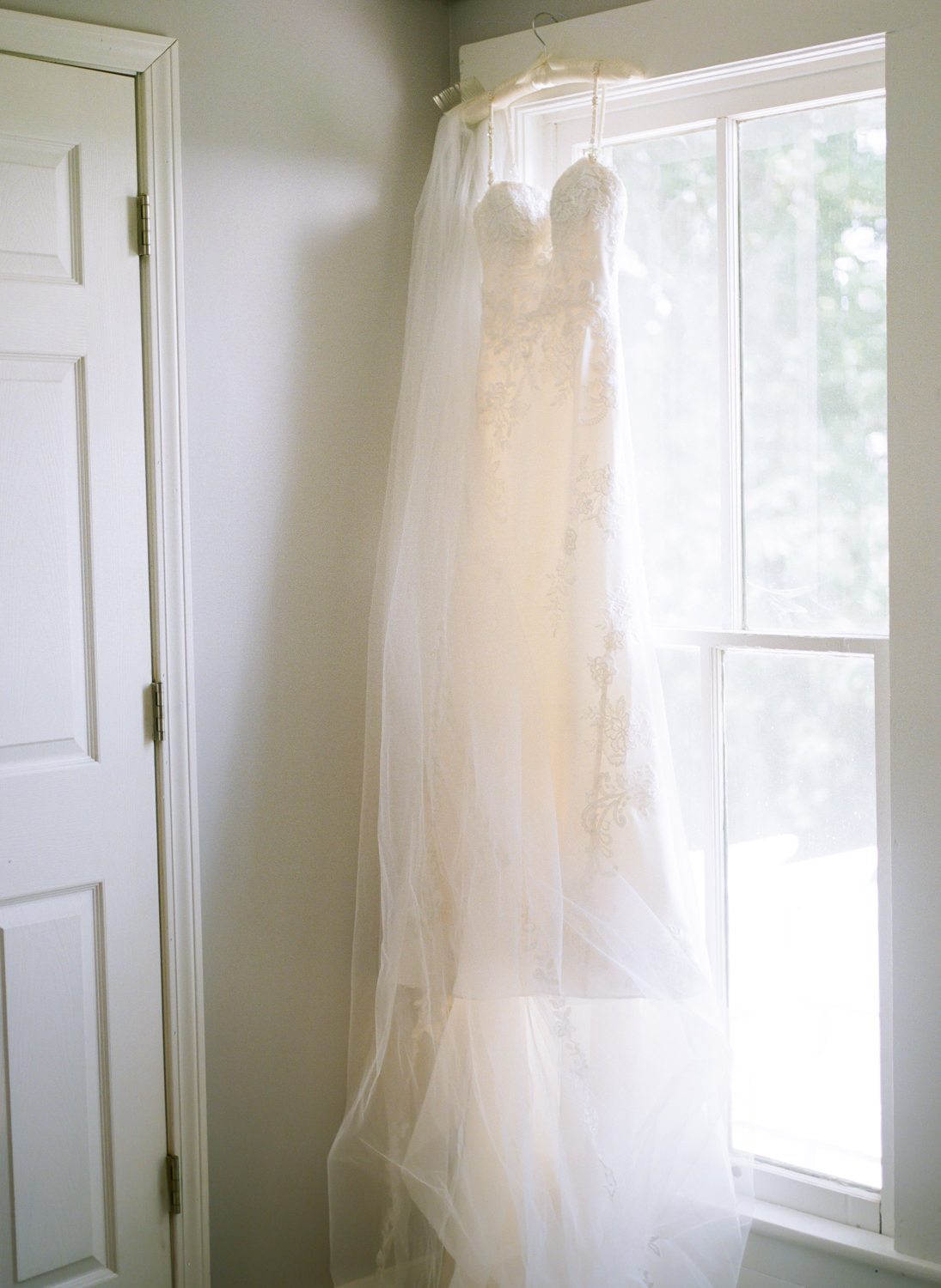 Wedding dress in window; St. Louis fine art film wedding photographer Erica Robnett Photography