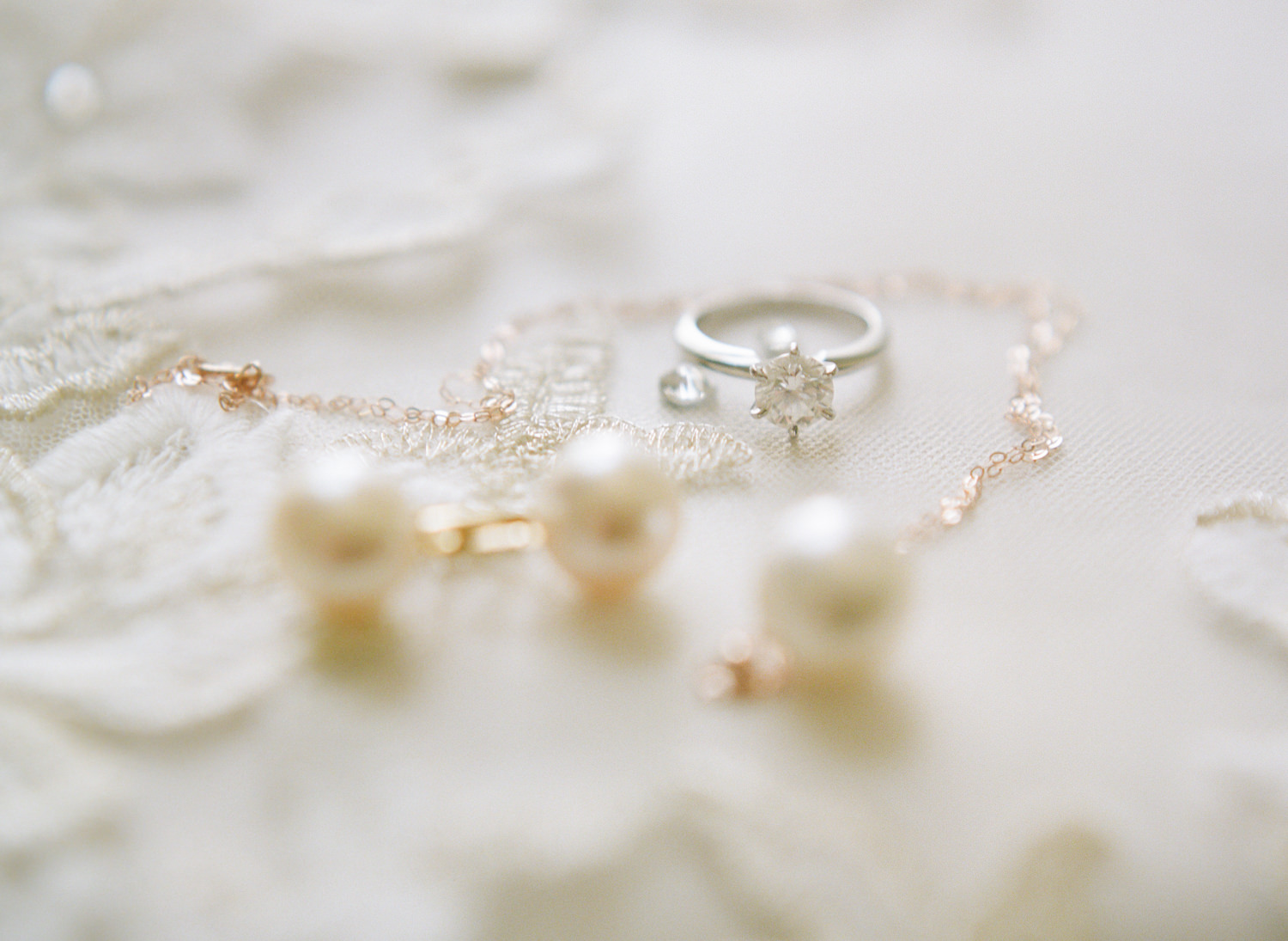 Engagement ring and pearl jewelry on veil; St. Louis fine art film wedding photographer Erica Robnett Photography