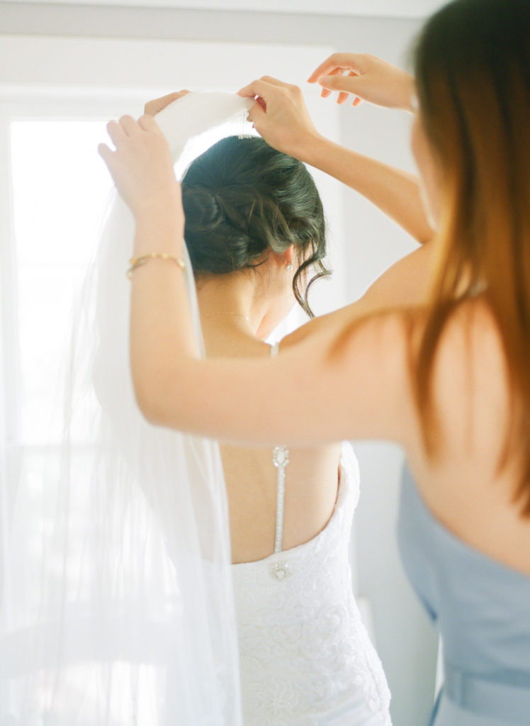 Bridesmaids putting on brides veil at Defiance Ridge Vineyards; St. Louis fine art film wedding photographer Erica Robnett Photography