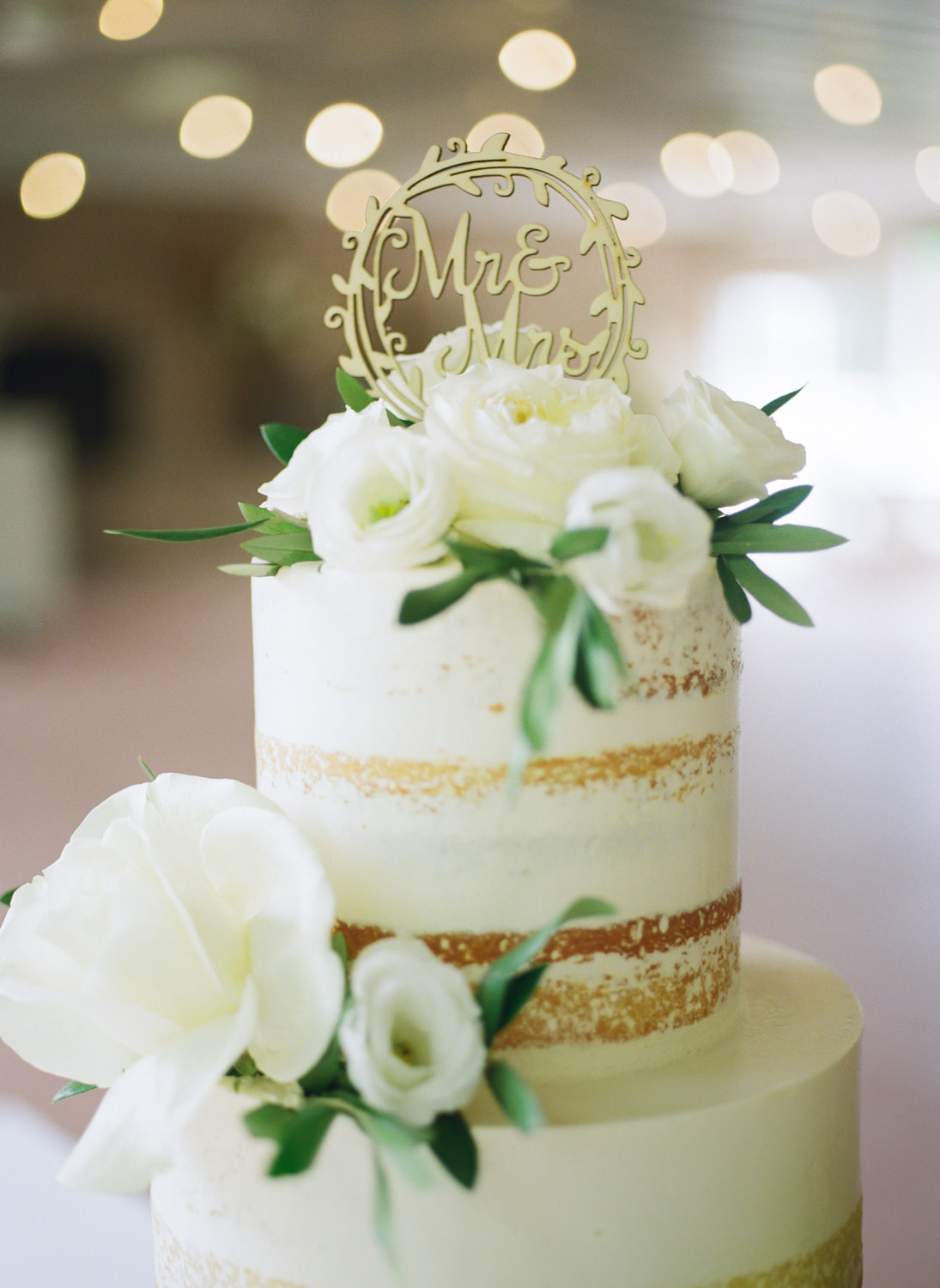 White 3 tier wedding cake with white flowers at Defiance Ridge Vineyards; St. Louis fine art film wedding photographer Erica Robnett Photography