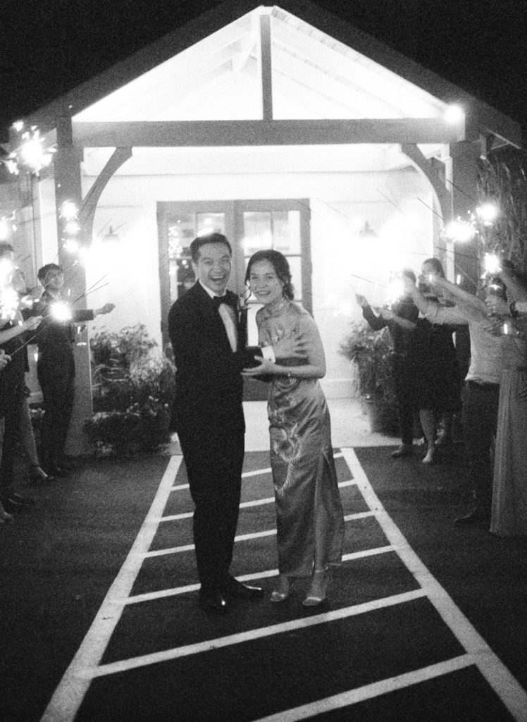 Grainy black and white film photo of bride and groom sparkler exit at Defiance Ridge Vineyards