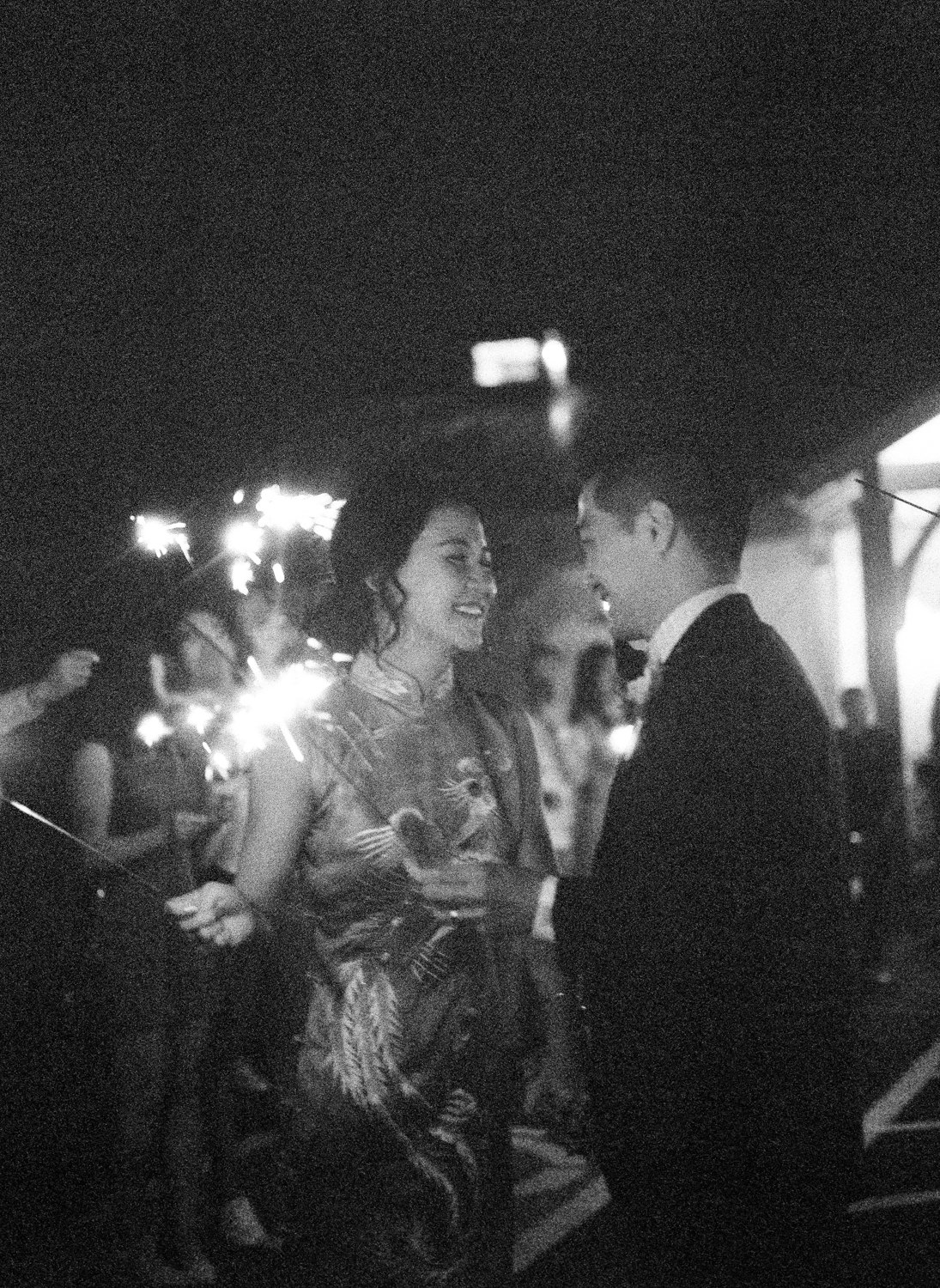 Grainy black and white film photo of bride and groom sparkler exit at Defiance Ridge Vineyards
