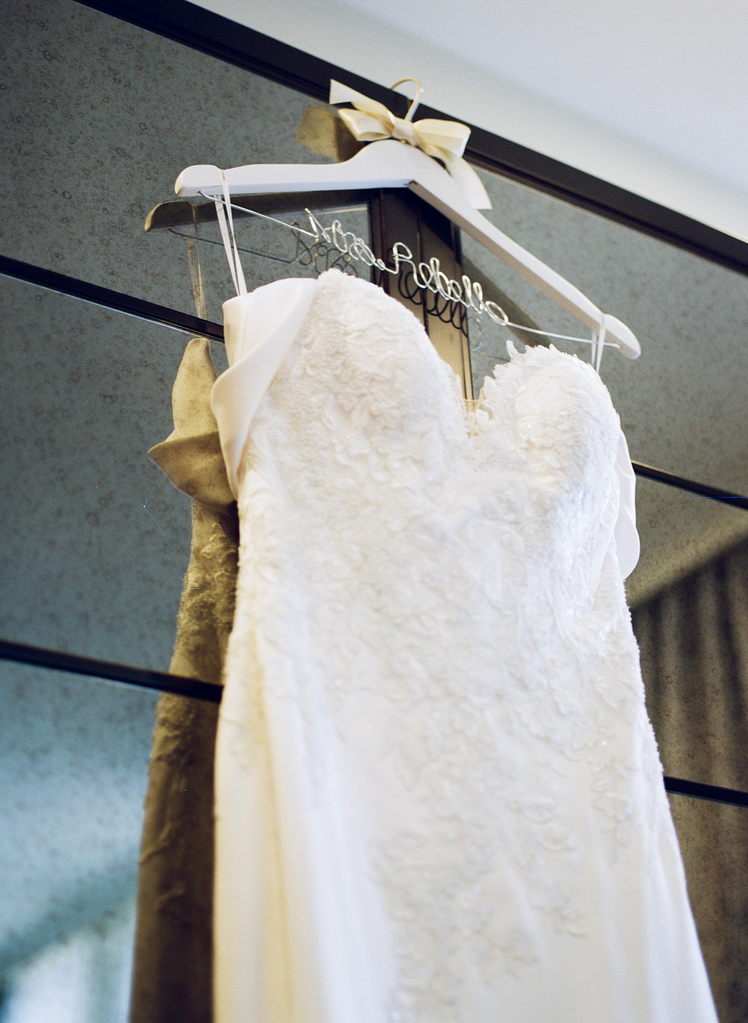 Wedding dress on hanger against mirrored closet door