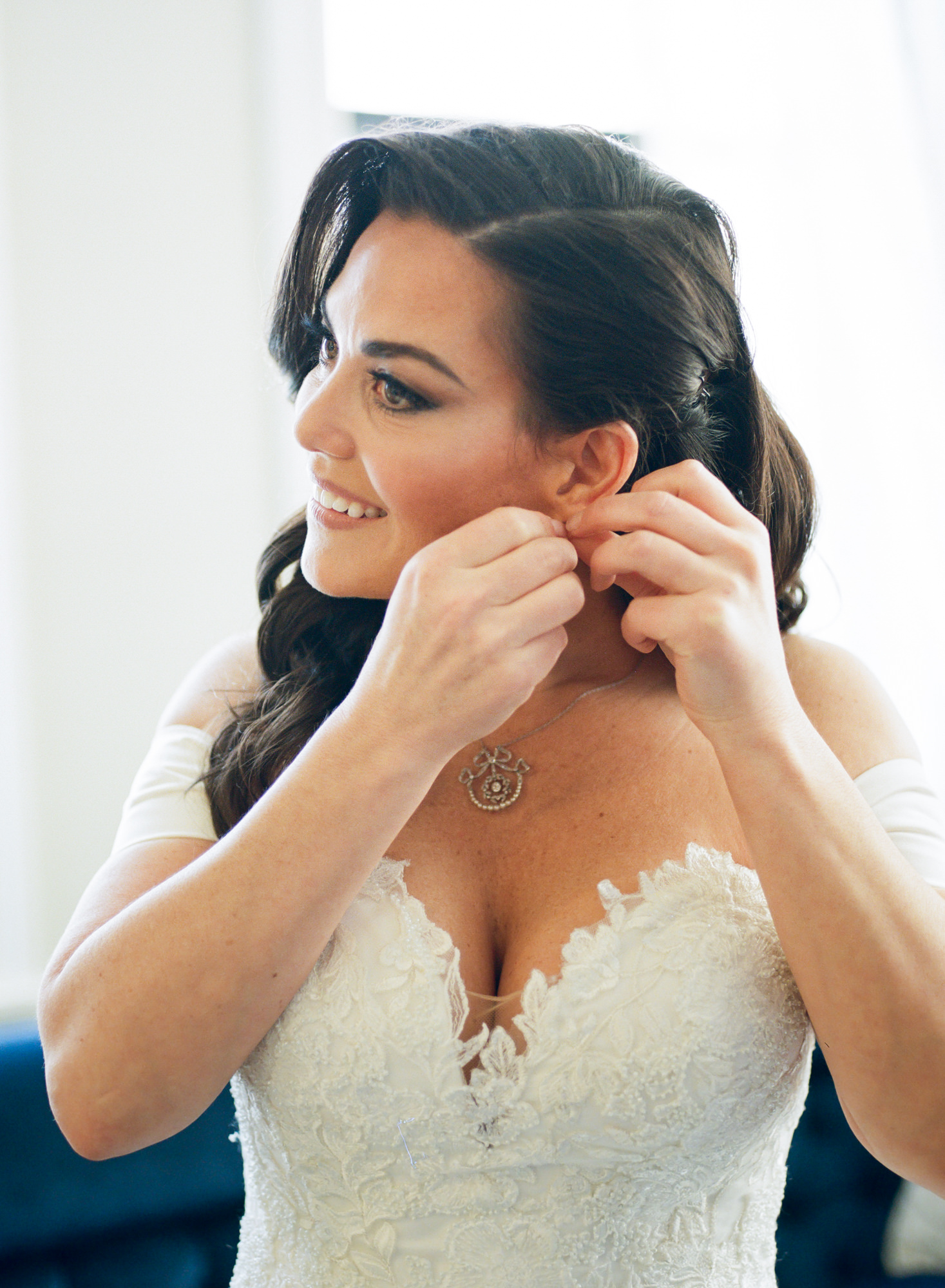 Bride putting on earrings; St. Louis fine art film wedding photographer Erica Robnett Photography