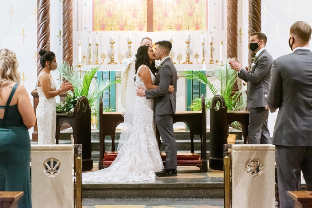Bride and groom kissing at wedding ceremony at St. John Paul II in St. Louis