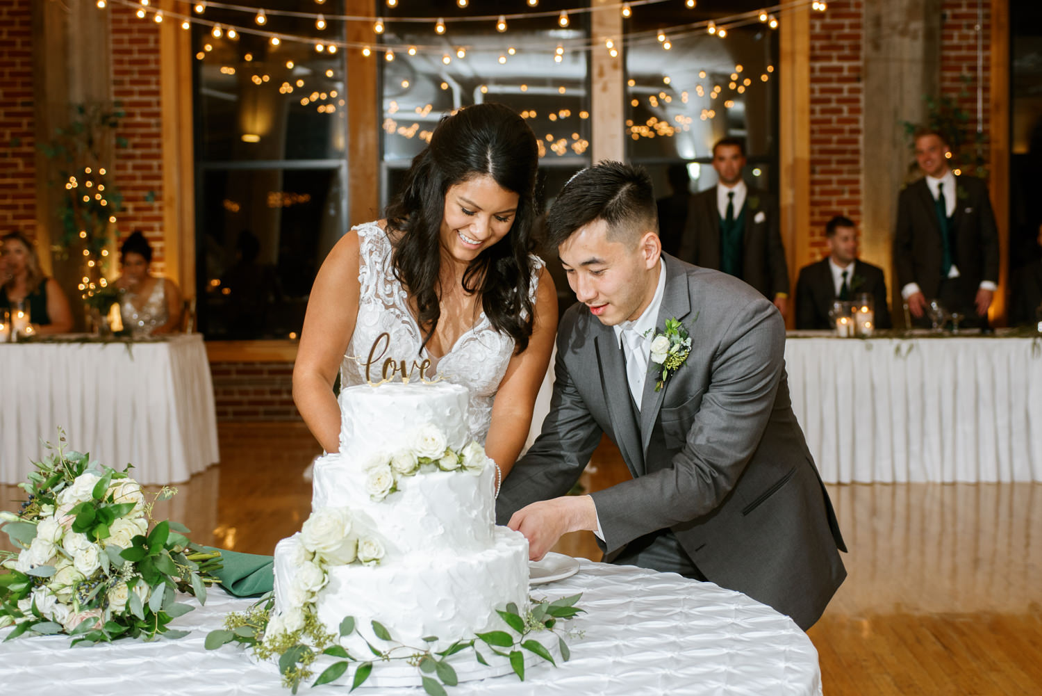 Bride and groom cut cake at St. Louis wedding venue Windows on Washington